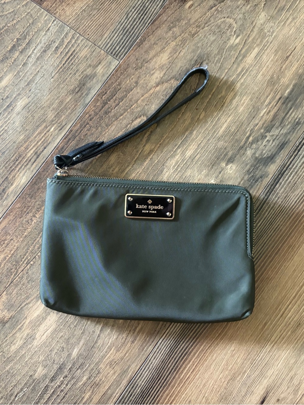kate spade olive green wristlet with black strap and logo plate